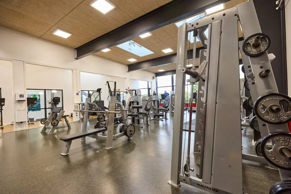 Lyst fitnesscenter med styrketræningsmaskiner, vægte og træningsbænke i Kraftværket Videbæk