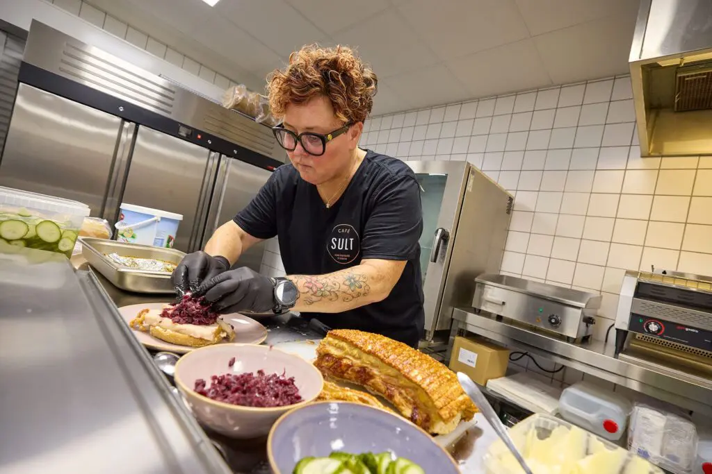 Pernille anretter flæskestegssandwich med rødkål i køkkenet hos Café SULT i Kraftværket Videbæk