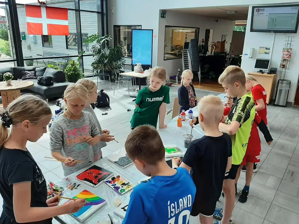 Børn der maler på lærreder ved et bord til børnefødselsdag i Kraftværket Videbæk
