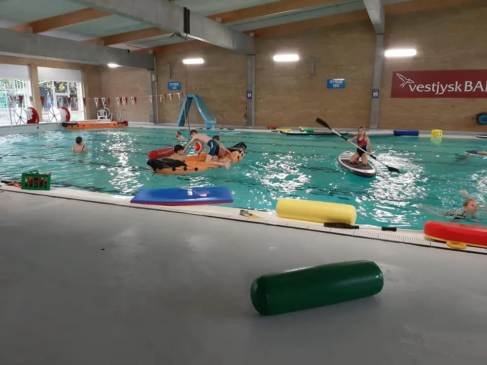 Børn der leger med oppustelig båd og paddleboard i svømmehallen hos Kraftværket Videbæk