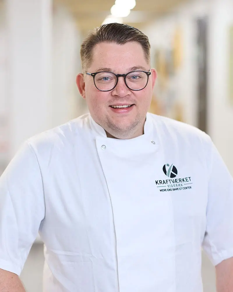 Portræt af Jannik Kristensen, køkkenchef og kok hos Kraftværket Videbæk, i hvid kokkejakke